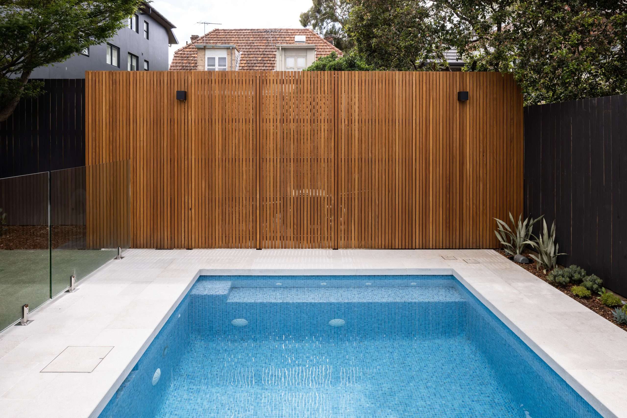 Blue fully tiled pool against timber batten fence, Mosman pool project by Refined Group