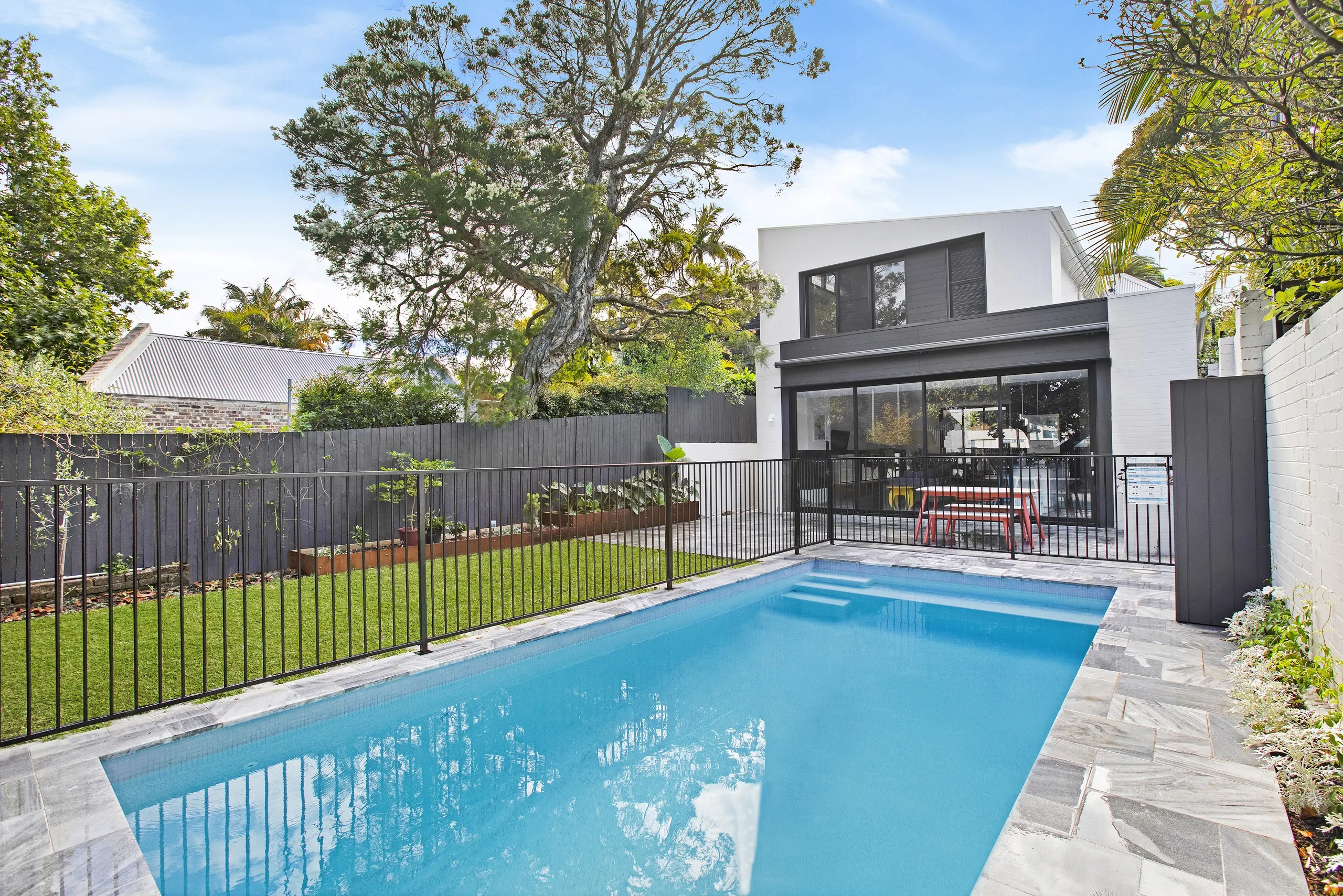 Concrete pool, marble surrounds and lawn behind a Balmain home, built by Refined Group