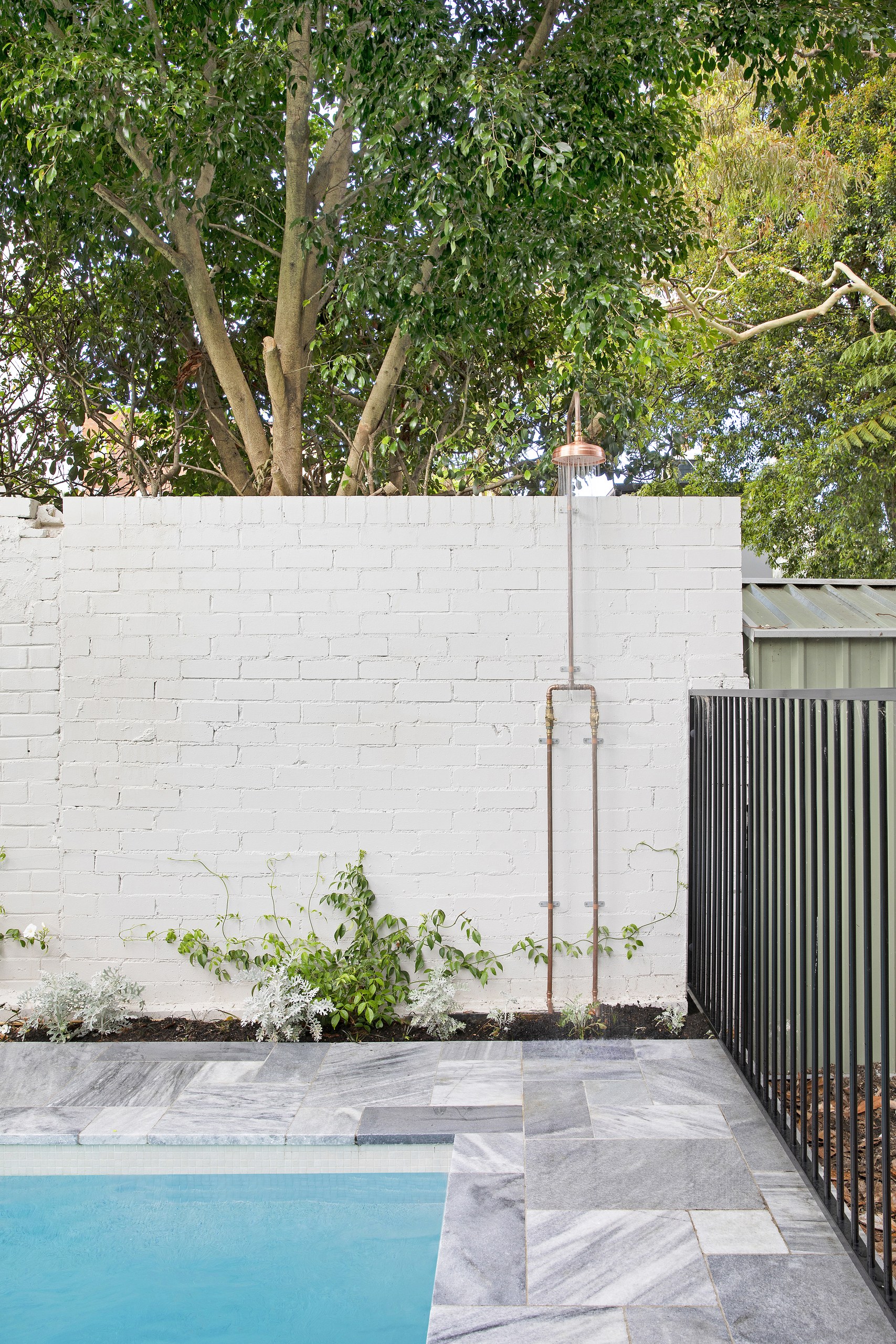 Copper outdoor shower on the white brick wall beside the pool, Balmain