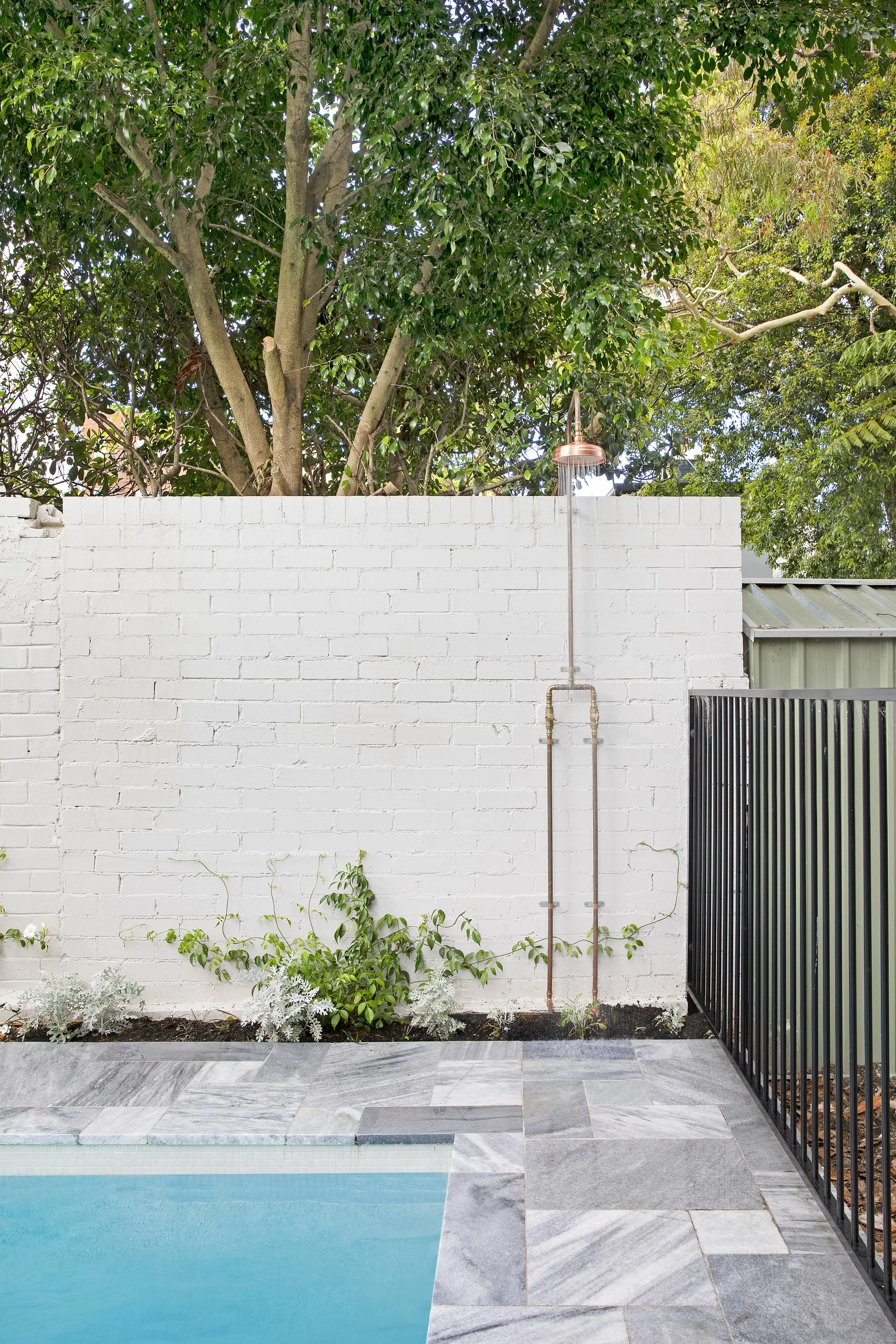 Copper outdoor shower on the white brick wall beside the pool, Balmain