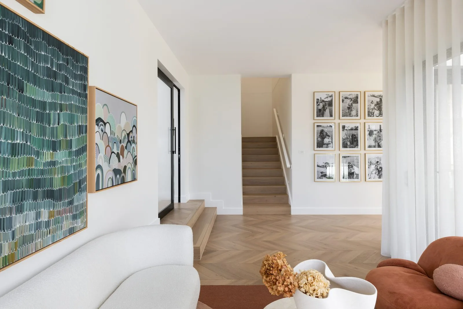 Living space with chevron oak floors and gallery wall in a Refined Group custom home