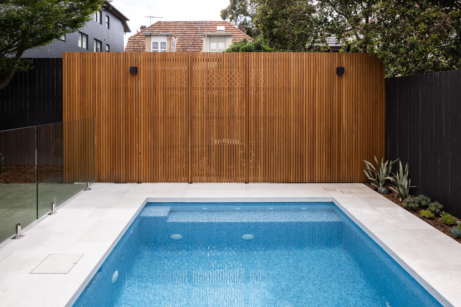 Fully tiled pool with timber batten feature wall, built by Refined Group in Mosman