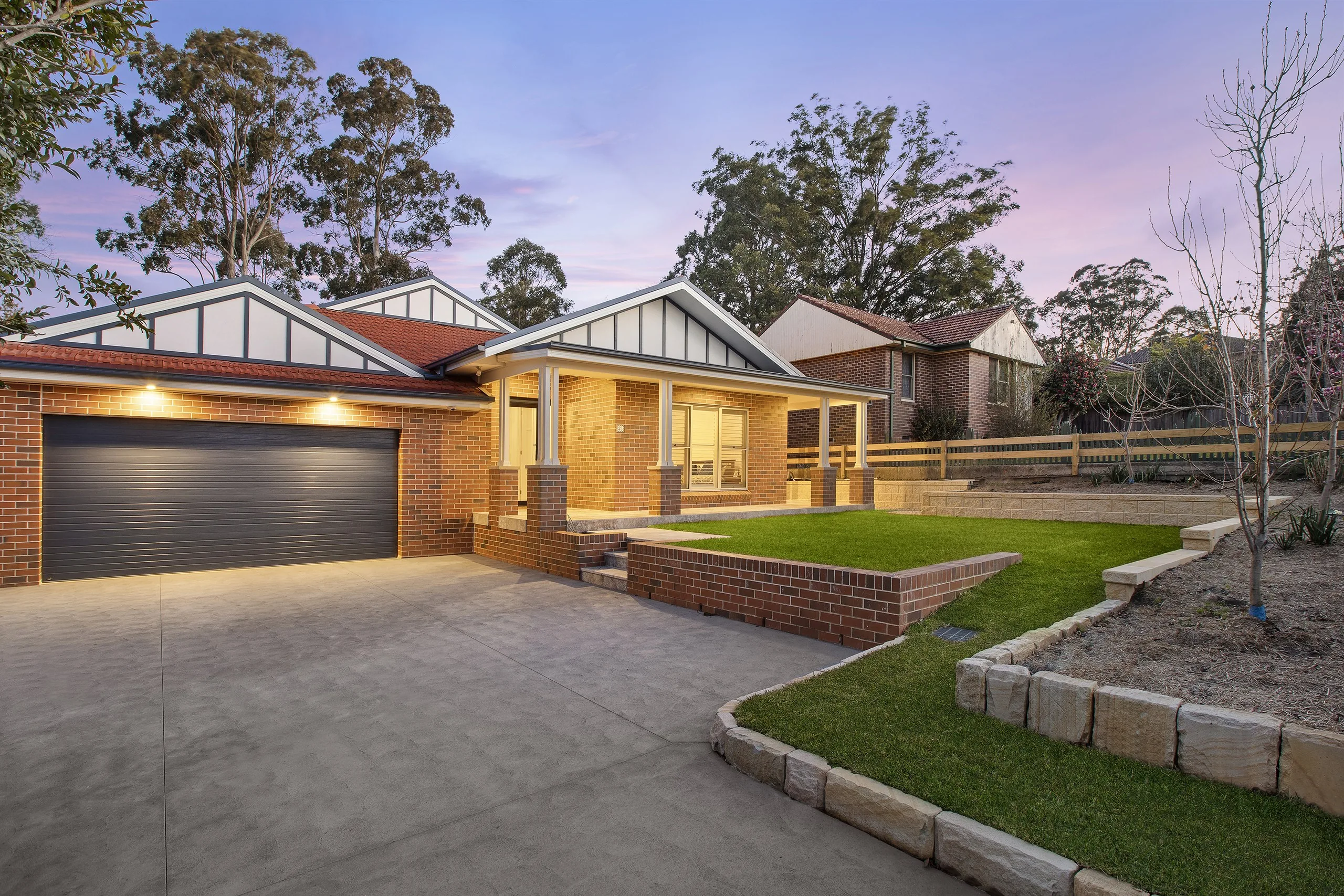 The new Pennant Hills home at dusk, with the pool built in behind it