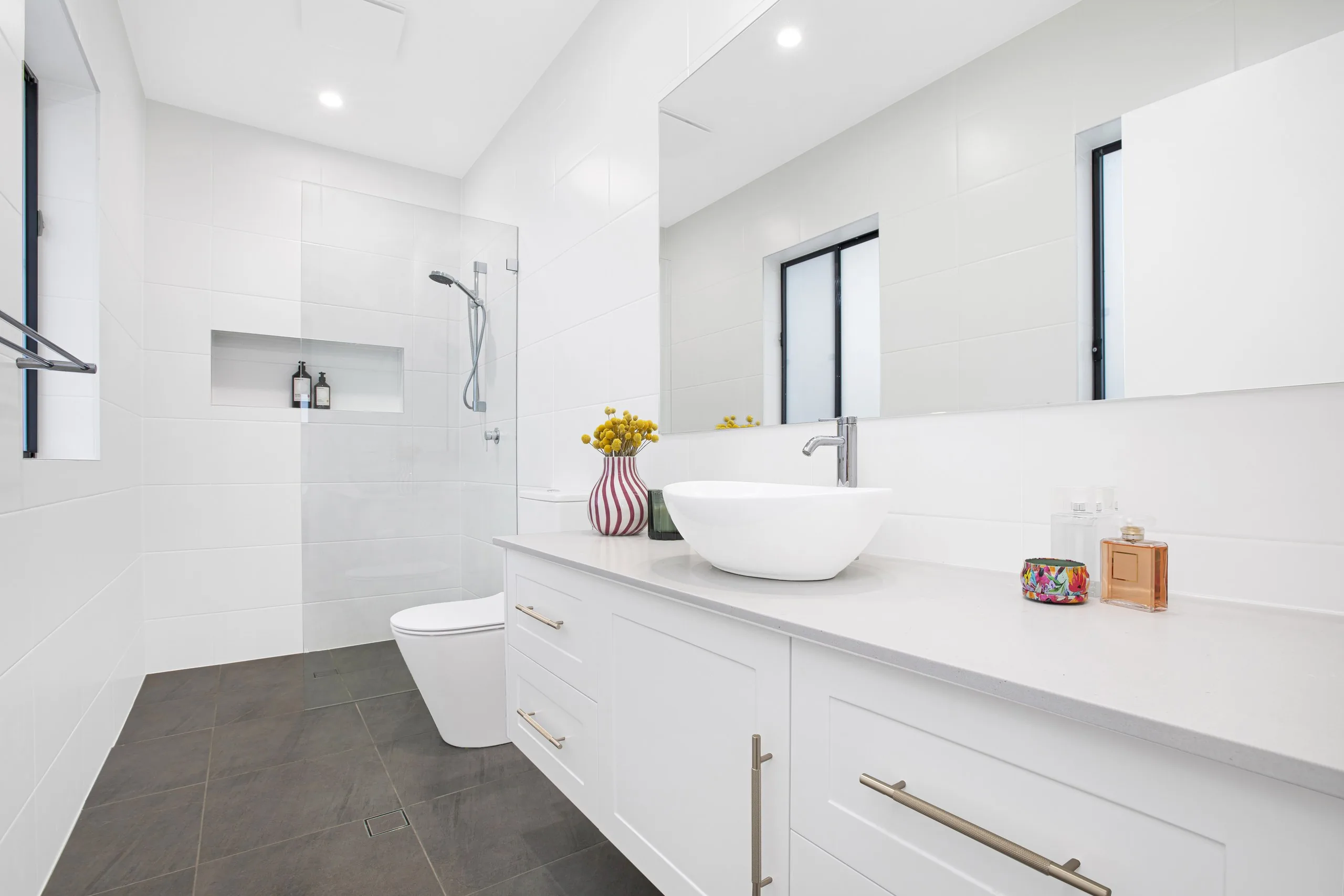 Main bathroom with stone floor tiles, twin windows and frameless shower, Seven Hills project