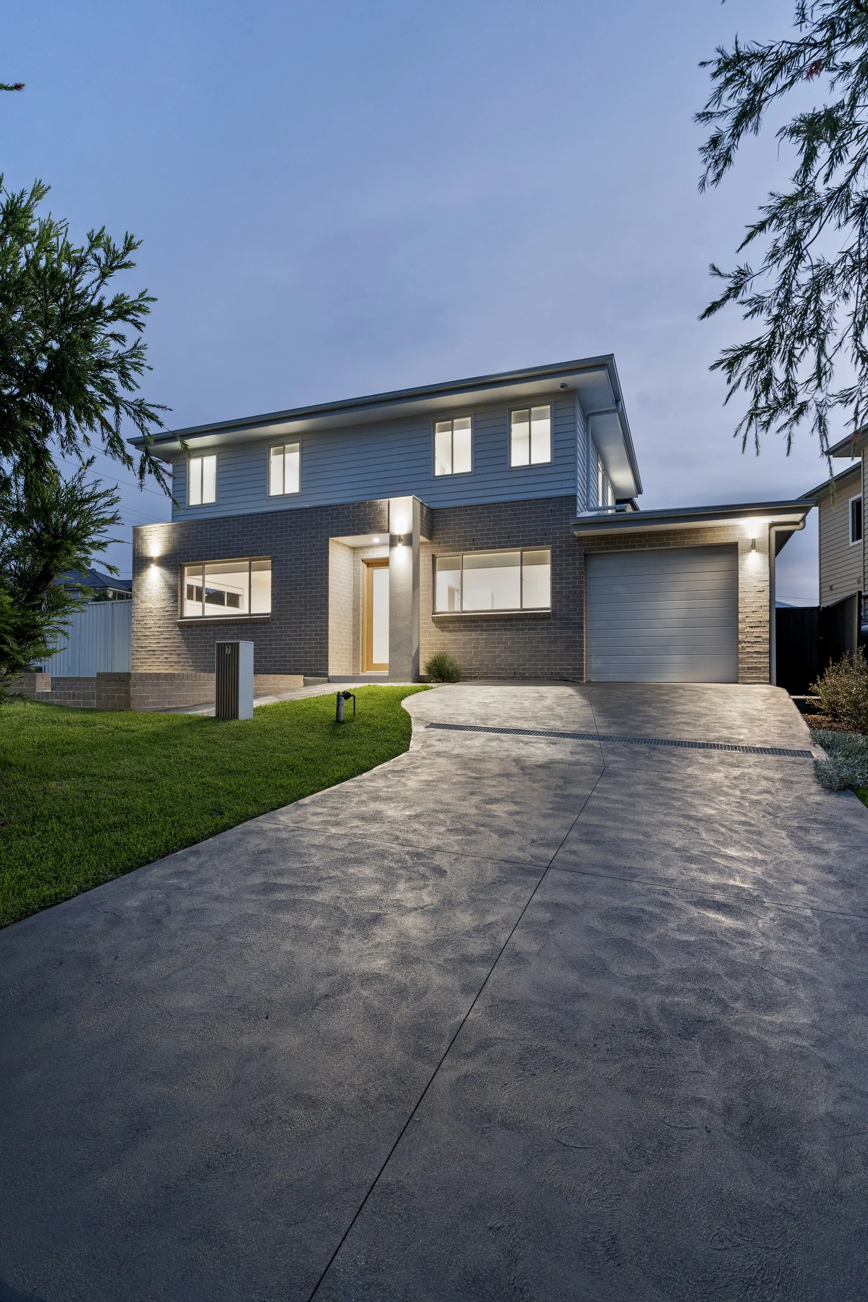 Dual occupancy facade at dusk with landscaped frontage, Seven Hills
