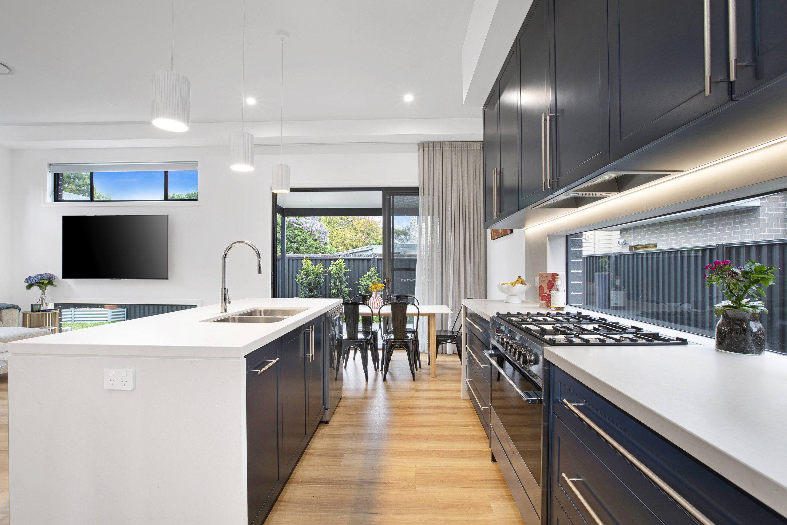 Navy kitchen with island bench and dining area, Seven Hills dual occupancy