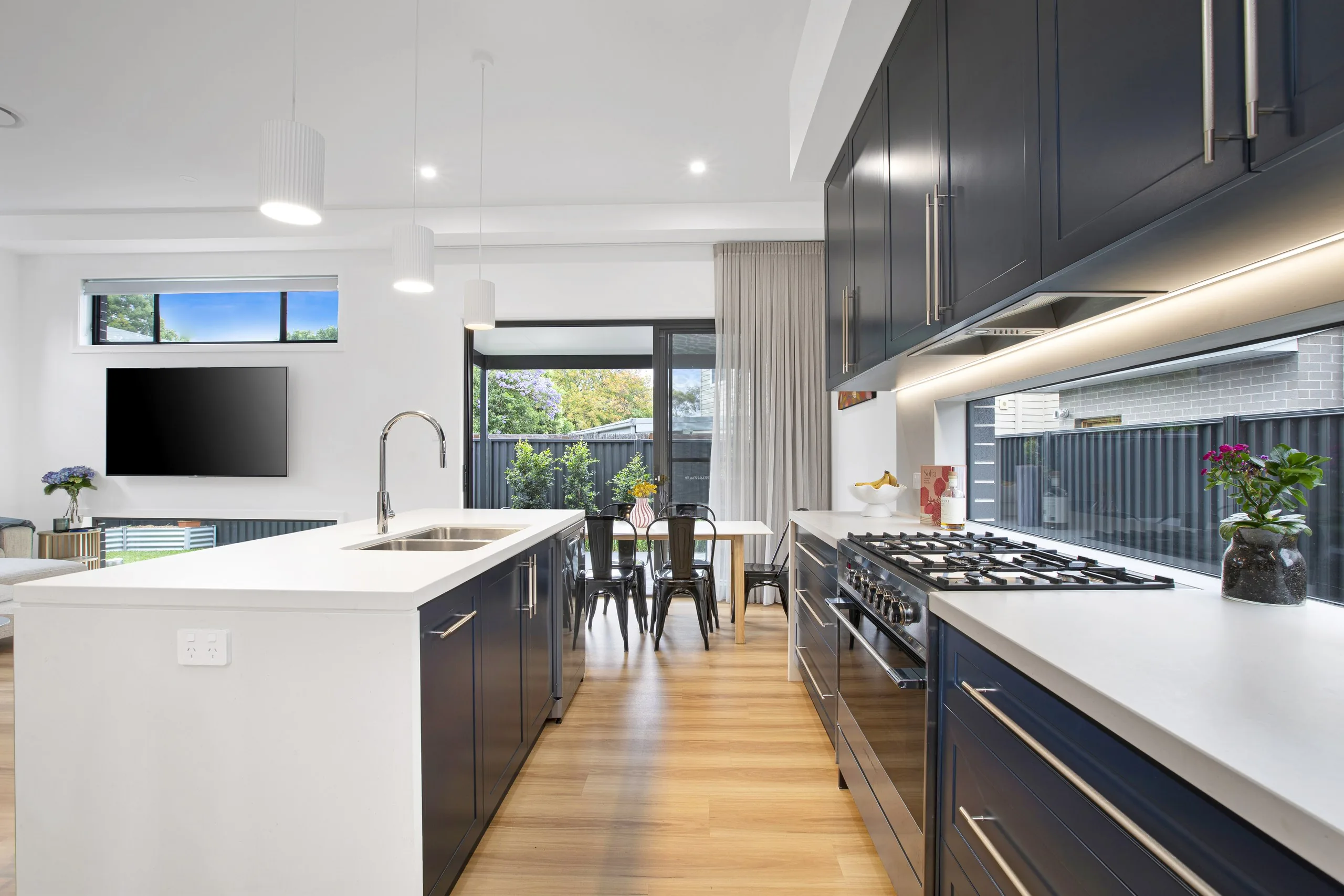 Navy kitchen with island bench and dining area, Seven Hills dual occupancy