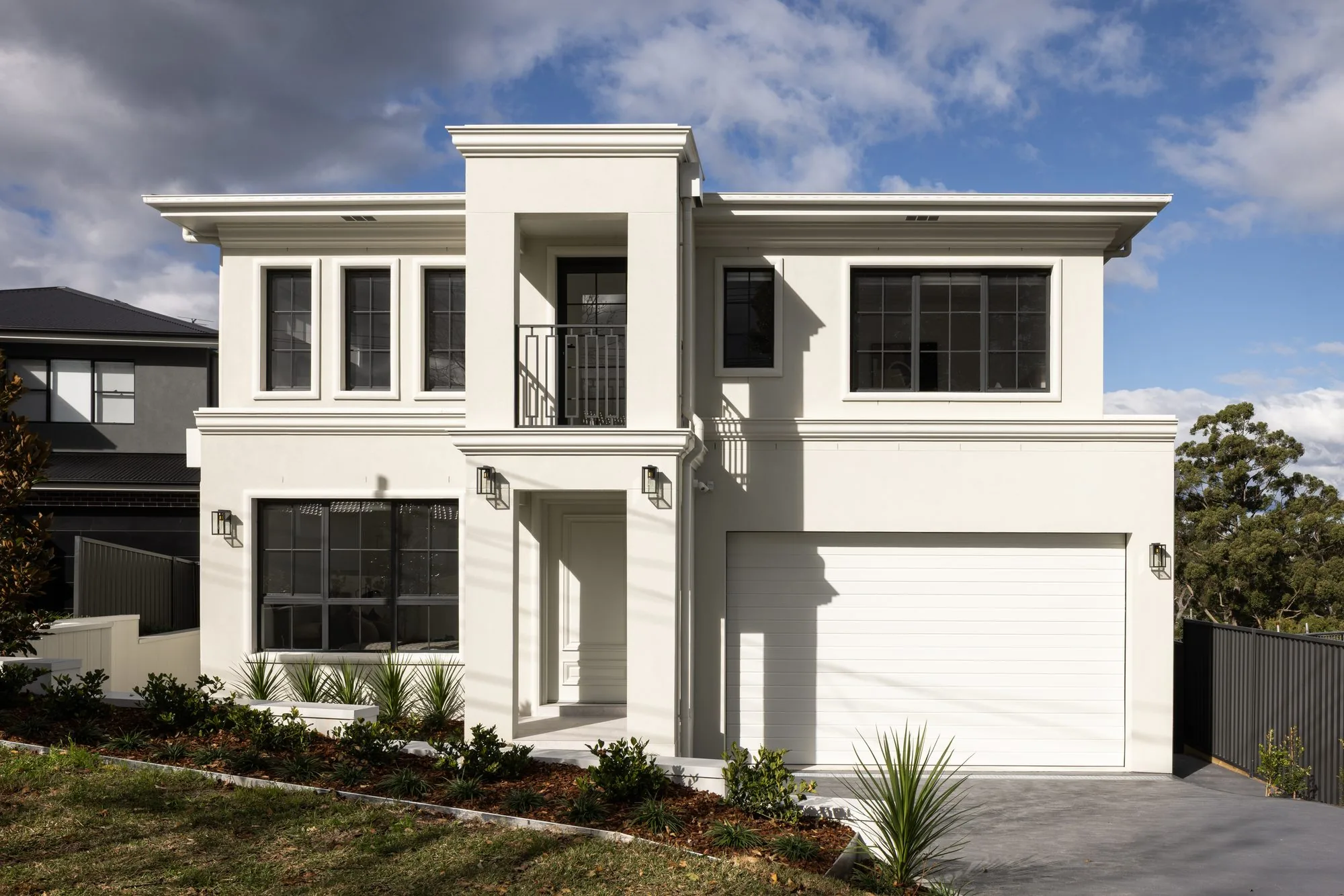 Split-level custom home with white rendered facade, Westleigh