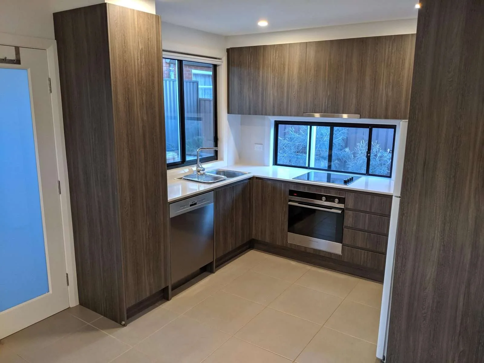Self-contained granny flat kitchen with stone benchtops and full-size appliances, Westmead