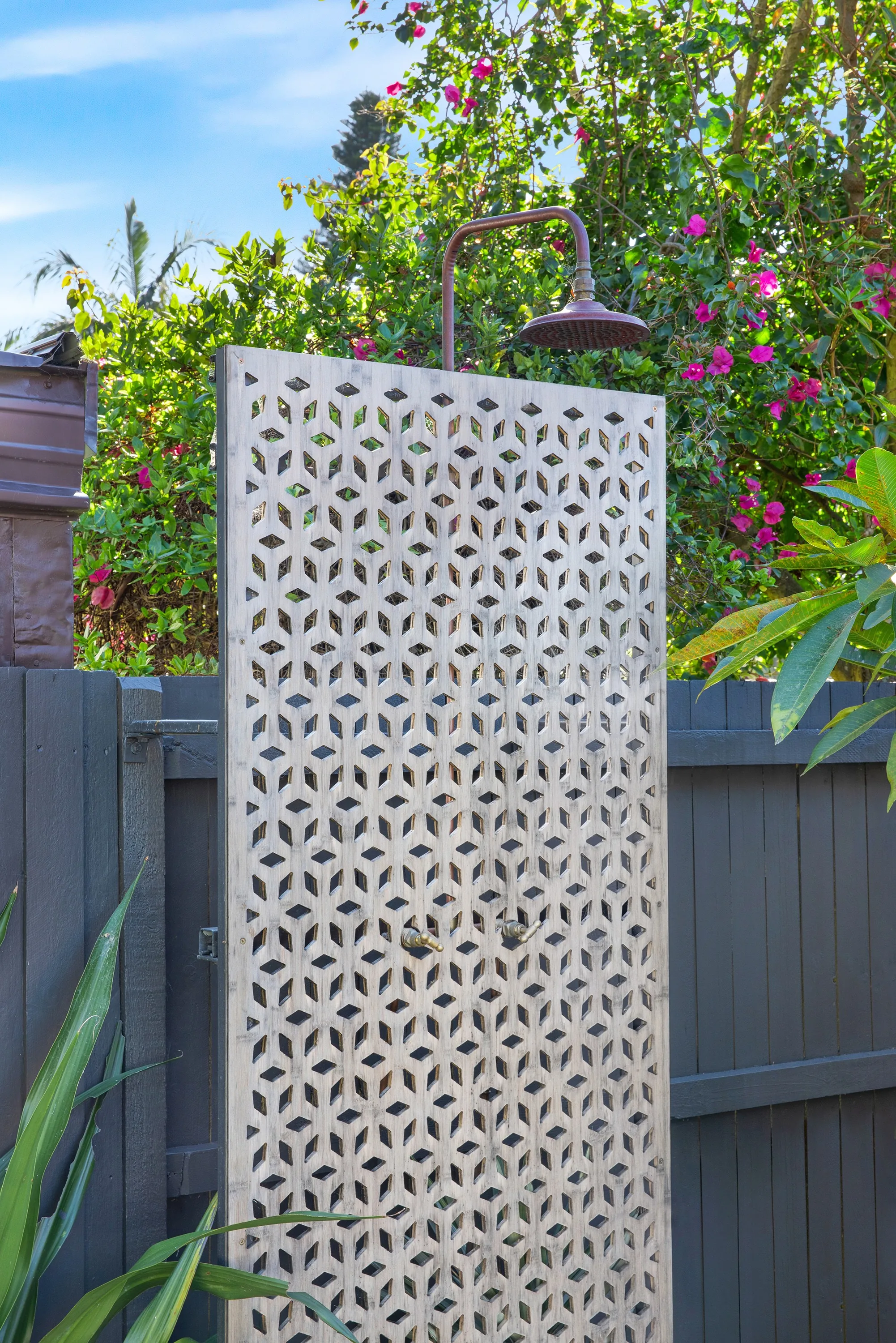 Copper outdoor shower against laser-cut privacy screen, Willoughby pool project