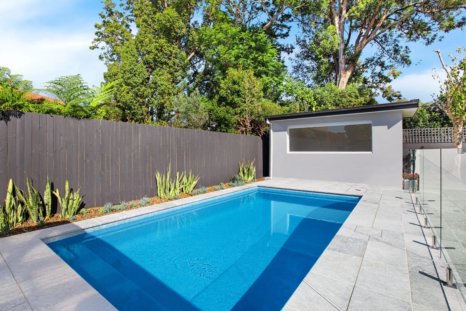 Custom concrete pool, travertine surrounds and pool house, Willoughby, built by Refined Group