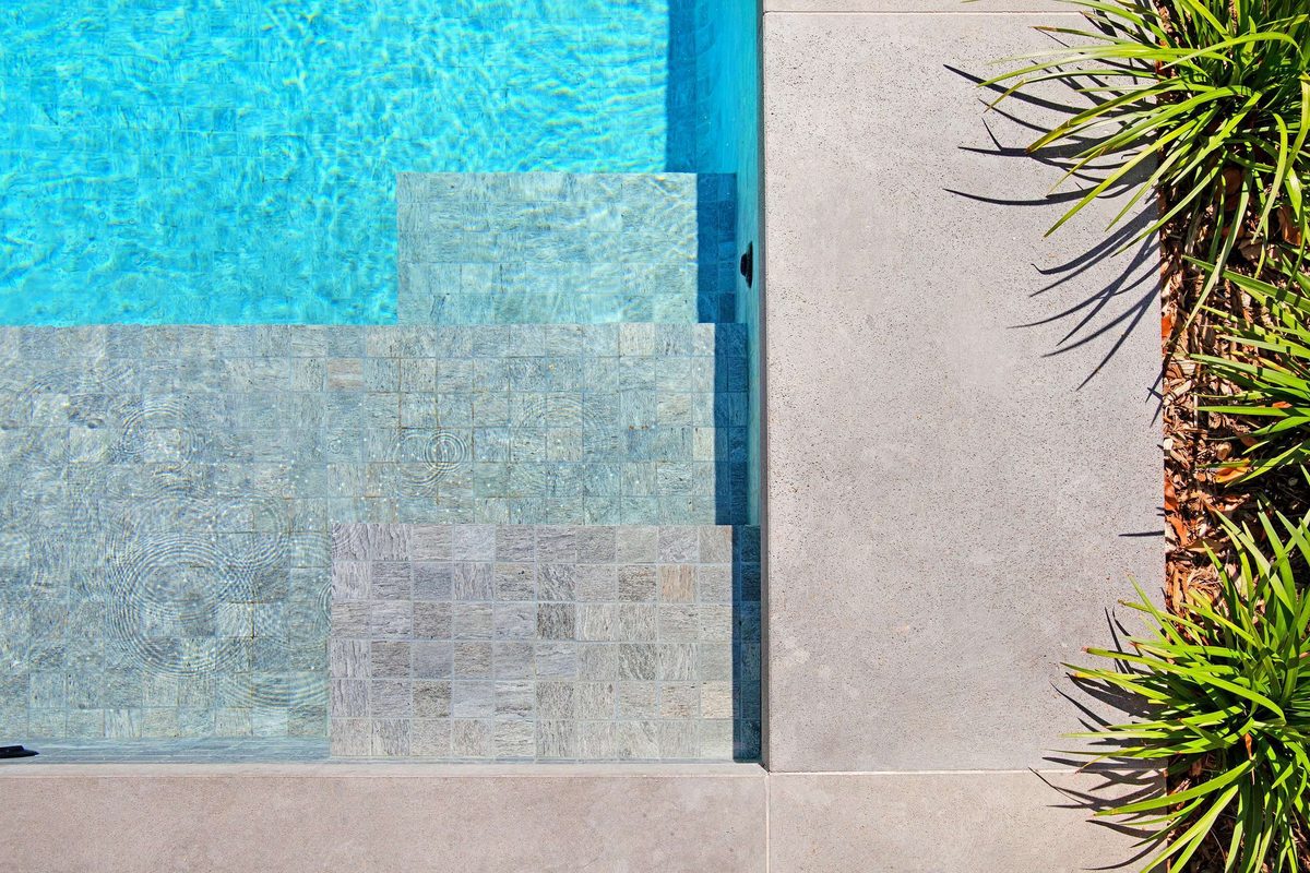 Fully tiled concrete pool with stone steps, built by Refined Group