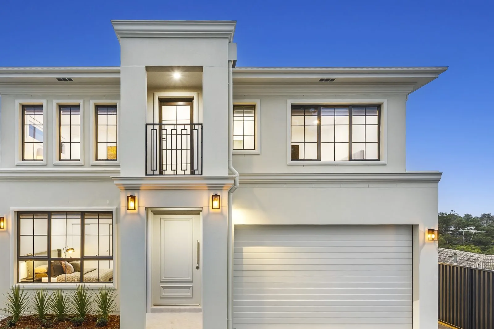 Provincial style custom home facade at dusk in Westleigh, built by Refined Group