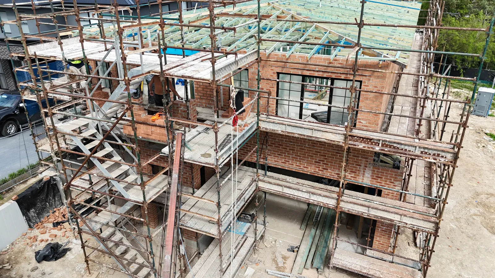 Brickwork going up inside the scaffold on a two storey home being built by Refined Group